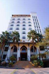 万象卡皮多尔酒店的一座高大的白色建筑,前面有棕榈树