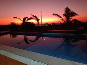 维加伊托Casa VerdeMar - Vichayito, Perú的棕榈树泳池和日落背景