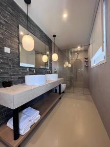 斯派赛斯Hotel Roumani的一间带两个盥洗盆和淋浴的浴室