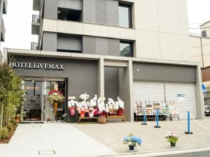 AsakaHOTEL LiVEMAX Saitama-Asaka-Ekimae的鲜花展示的建筑物前的商店