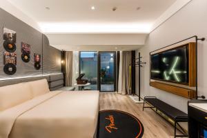 苏州苏州盘门古运河轻居音乐酒店的酒店客房设有一张大床和一台电视机。