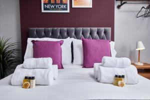 达宁顿堡Delven House, Apartment 4的卧室配有紫色枕头和白色床。