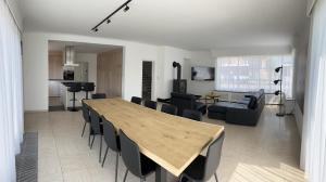 阿丁凯尔克villa dunepanne的用餐室以及带木桌和椅子的客厅。