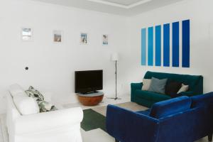 大加那利岛拉斯帕尔马斯KYO Surf Hostel的客厅配有蓝色的沙发和电视