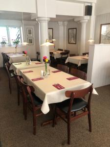 里伯Restaurant Backhaus的用餐室配有桌椅和鲜花