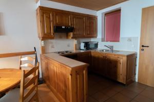 特雷芬Apartment Panorama Gerlitzen的厨房配有木制橱柜、水槽和桌子