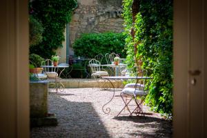 圣雷米普罗旺斯La Maison du Village的户外庭院设有桌椅和植物