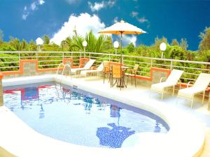 姆特瓦帕蒙娜丽莎酒店的一个带椅子和桌子的游泳池以及一把遮阳伞