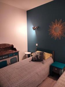 Pruniersla dabinerie的一间卧室设有一张床和蓝色的墙壁