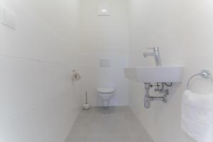 韦尔特湖畔克伦彭多夫Apartments Oasis Wörthersee neu & zentral的白色的浴室设有水槽和卫生间。