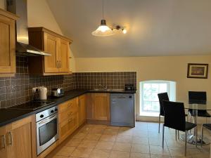 凯尔斯2 Bed Courtyard Apartment at Rockfield House Kells in Meath - Short Term Let的厨房配有木制橱柜和桌椅