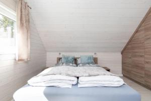 波别罗沃Kotwica-Pobierowo Bukowa 1的一间卧室配有一张带蓝色枕头的大床