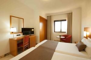圣克鲁斯-德特内里费和平王子酒店的酒店客房配有一张床、一张书桌和一台电视。