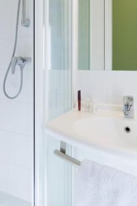 沙西约宜必思里昂国际展会经济酒店的浴室设有白色水槽和镜子