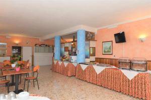 巴多利诺Albergo Panoramica的一间带桌子的客厅和一间带蓝色柱子的厨房