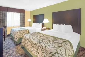 霍兰荷兰贝蒙特麦克罗特客栈&套房的酒店客房设有两张床和一张带台灯的桌子。