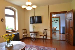 莱比锡莱比锡阿尔特巴斯塔希公寓（TWO＆ONE公寓）的客厅配有桌椅和电视。