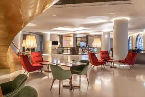 蓬塔德尔加达大西洋亚速尔格兰德酒店的大堂设有红色的桌椅和厨房