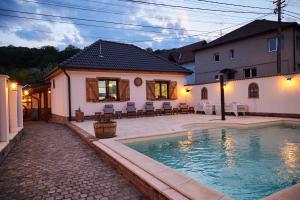 梅迪亚什Complex Butoaiele Transilvaniei - Cazare & SPA - Natura - Restaurant的房屋前有游泳池的房子