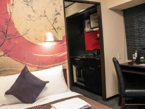 京都HOTEL LiVEMAX Kyoto Ekimae的酒店客房带一张床、一张书桌和一面镜子