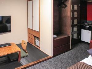 京都HOTEL LiVEMAX Kyoto Ekimae的一间带书桌的客厅和一间带壁炉的房间