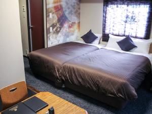 京都HOTEL LiVEMAX Kyoto Ekimae的一间卧室配有一张带蓝色枕头的大床