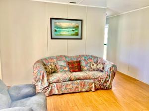 朱里恩湾Cottage 55 - Topspot Cottages的客厅的沙发,配有绘画作品