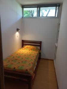 波萨达斯Parana Riverside Guest House - Posadas的一间带床的卧室,位于带窗户的房间内