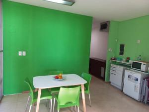波萨达斯Parana Riverside Guest House - Posadas的厨房设有绿色的墙壁和桌椅