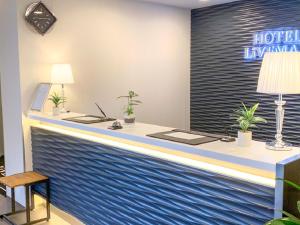 冈山HOTEL LiVEMAX Okayama West的酒店大堂的前台,设有蓝色的墙壁