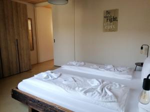 卢塞恩Easy-Living Kriens Apartments的墙上有标牌的房间,配有两张白色的床