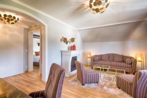 欣特察尔滕阿德勒公园酒店的客厅设有两张沙发和一个壁炉