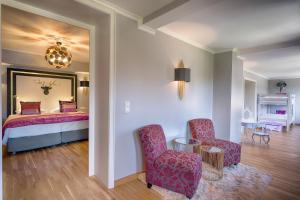 欣特察尔滕阿德勒公园酒店的一间卧室配有一张床、两把椅子和一张桌子