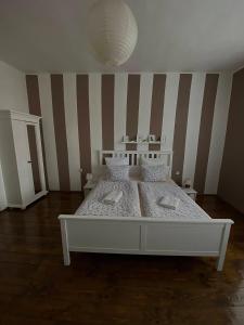 拉贝河畔乌斯季Ubytování Stará的一间有条纹墙的房间里一张白色的床