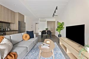 悉尼Cinema Suites Apartments by Urban Rest的带沙发和电视的客厅