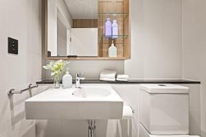 悉尼Cinema Suites Apartments by Urban Rest的白色的浴室设有水槽和卫生间。
