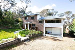 肯图巴The roses house - Cozy and Modern house in Katoomba的一座砖房,在院子里设有车库
