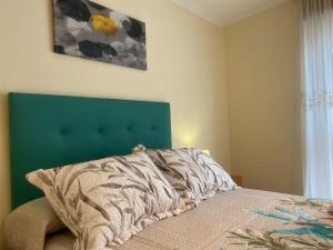 拉林APARTAMENTO FUNCIONAL LALIN-CENTRO的一间卧室配有一张带绿色床头板的床