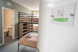 NewcastletonNewcastleton Bunkhouse的一间卧室设有两张双层床,上面标有读森林的标志
