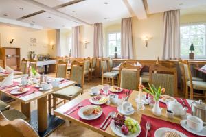 诺伊豪森Landhaus Purschenstein的一间餐厅配有桌椅,提供食物