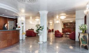 里米尼加丽雅皇宫酒店的大楼内带红色椅子的大堂和酒吧