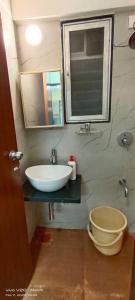 孟买CITY HOMES PARADISE APARTMENT的一间带水槽、卫生间和镜子的浴室