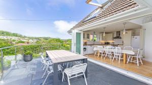 布朗顿Rooftops Braunton, Stylish Beach House - Fantastic Views - Hot Tub hire - Sleeps 8的一个带桌椅的庭院和一间厨房