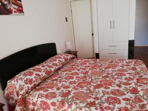 安托法加斯塔Zigal hotel的一间卧室配有一张带花卉床罩的床