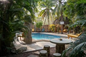 波特雷罗Villas Pura Vibra的庭院内的游泳池,配有桌椅