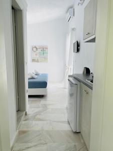 波利克罗诺Lefki villa的一间白色的小厨房,在房间内配有一张床
