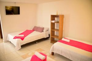 金巴亚Hotel Casa Alejandria的小房间设有两张床和电视