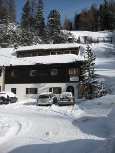 上陶恩豪斯伊丽莎白公寓式酒店的两辆汽车停在一座建筑物前面的雪地里