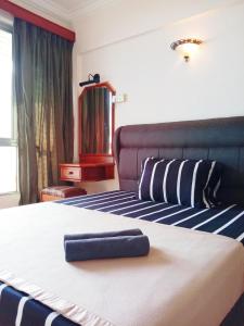 波德申Glory Beach Resort PriVate PentHouse的一间酒店客房,配有一张带毛巾的床