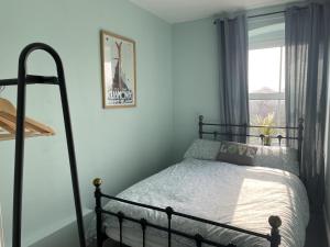 哈罗盖特Lovely 2-Bed flat in Summerbridge Harrogate的一间卧室设有一张床和一个窗口